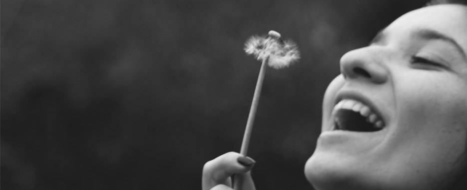 foto blanco y negro con persona soplando flor